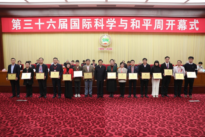 11.第十二屆全國政協副主席齊續春向榮獲第三十六屆國際科學與和平周“最佳活動組織單位”的代表頒發榮譽牌.jpg